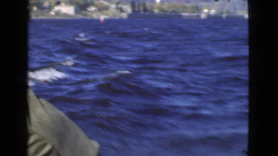 Handheld 8mm view from the boat shows rippling Quebec lake water with a partial figure at the left edge.