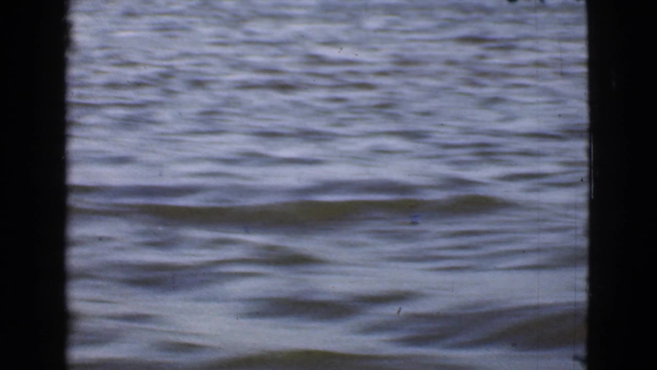 Open rippling water framed by dark vertical boat edges.