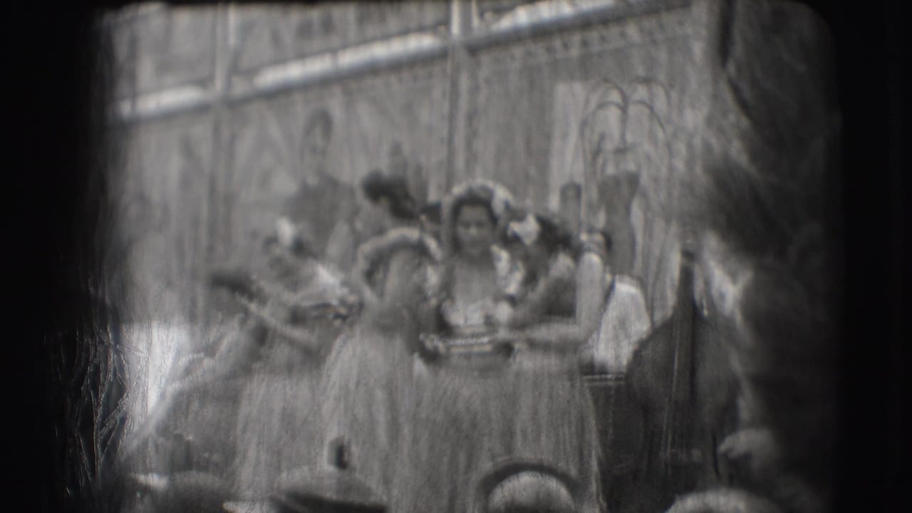 Several costumed women stand together on stage during a hula-style performance.