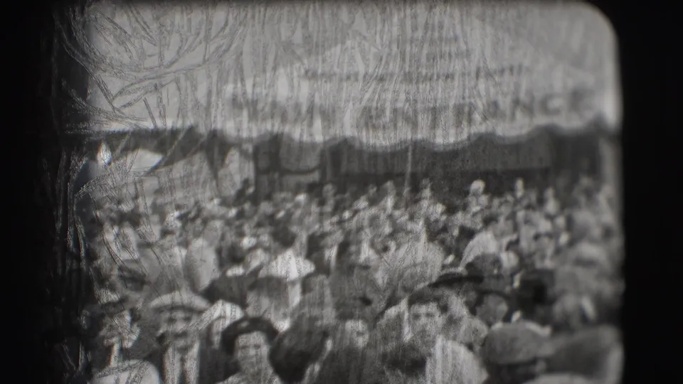 1948 Sarasota circus entrance crowd seen in soft black-and-white 8mm, with adults moving beneath a canopy.