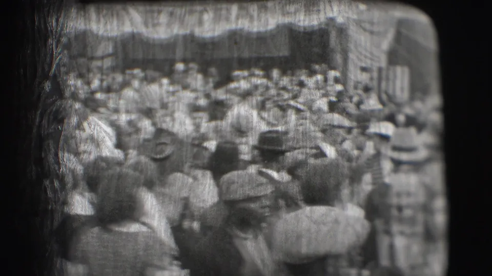 Black-and-white home-movie view of the Sarasota circus entrance crowd, showing visitors moving beneath the canopy.