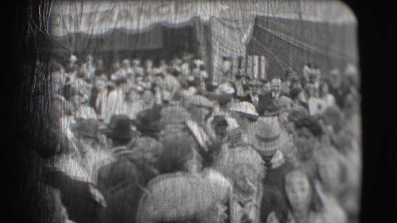 Crowd of spectators in hats gathered near a circus entrance.