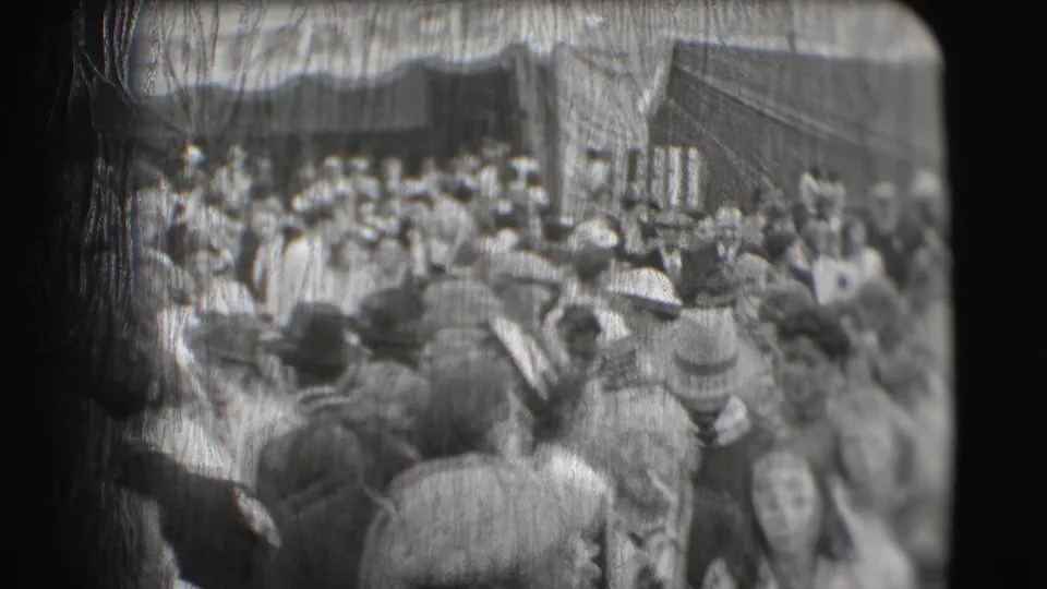 1948 Sarasota circus crowd viewed from behind, with many hat-wearing spectators near an entrance area.