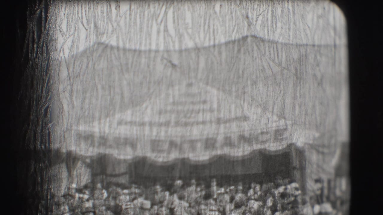 Wide crowd below a large tent or awning at an outdoor event.