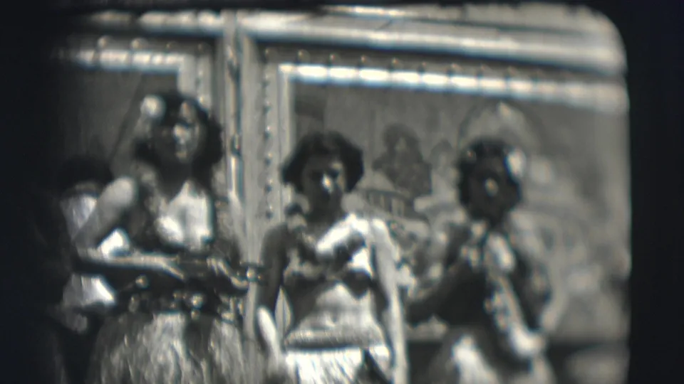 1948 Sarasota circus frame showing three women in performance costume, one with a fan-like prop.