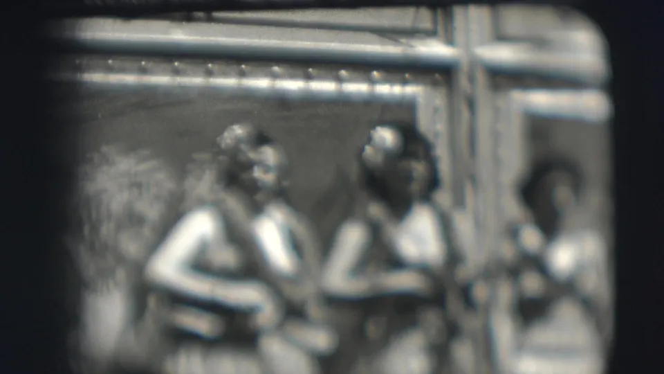 Soft, blurred 1948 home-movie frame of women with instruments and leis near tent supports at the Sarasota circus location.