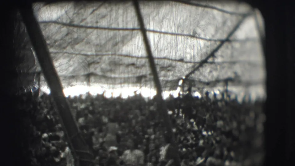 Final 1948 circus-tent view showing a dense audience beneath canvas, framed by dark support poles and soft 8mm grain.