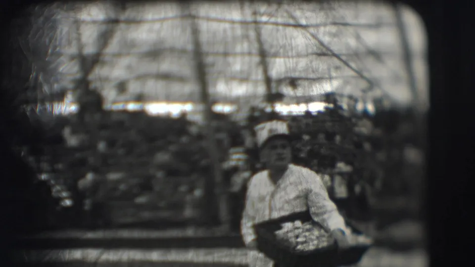 In 1948 Sarasota footage, a uniformed man sits at a table with a food tray inside a barracks-like space lined with cots.
