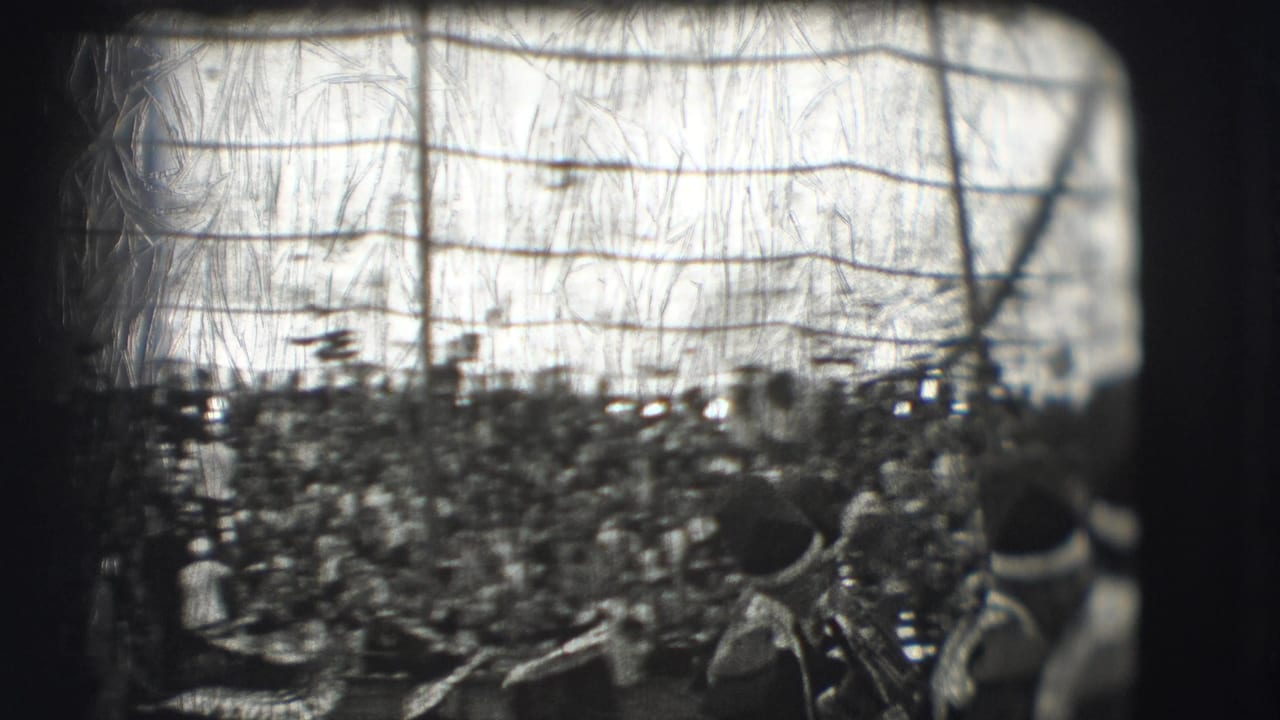 Crowded circus grandstand seen through a scratched 8mm film frame.