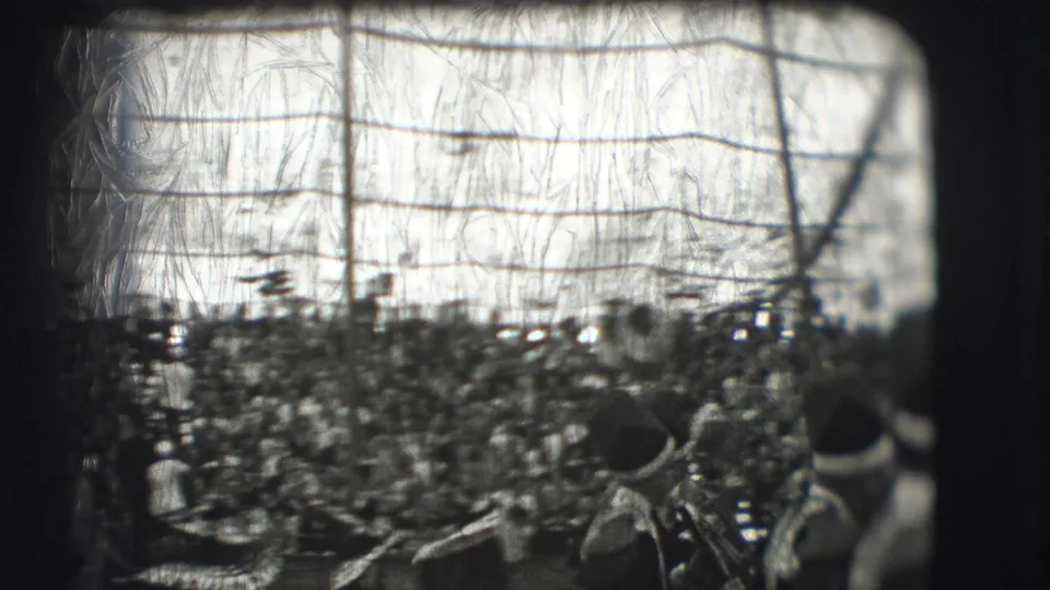 1948 Sarasota circus crowd viewed from the audience area, with packed stands, hats, rigging lines, and heavy film wear.