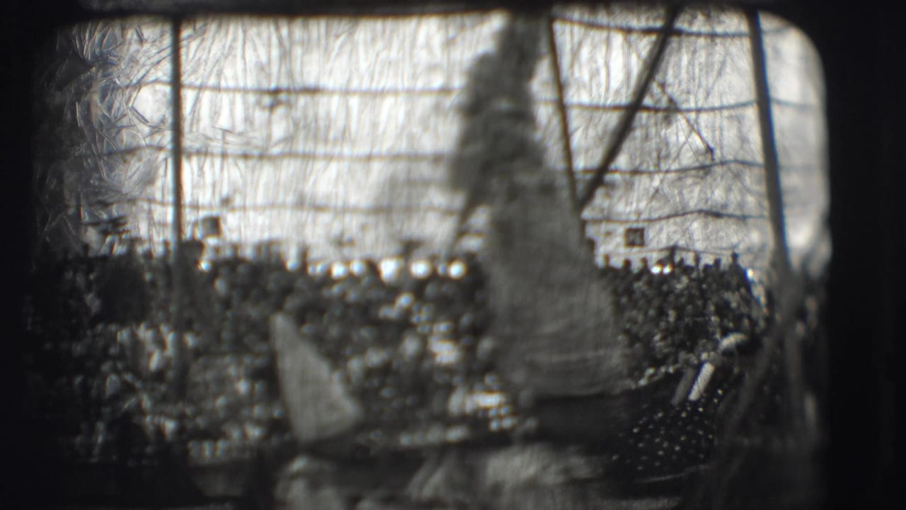 Crowded circus tent scene with tall-hatted figures in front of audience seating.