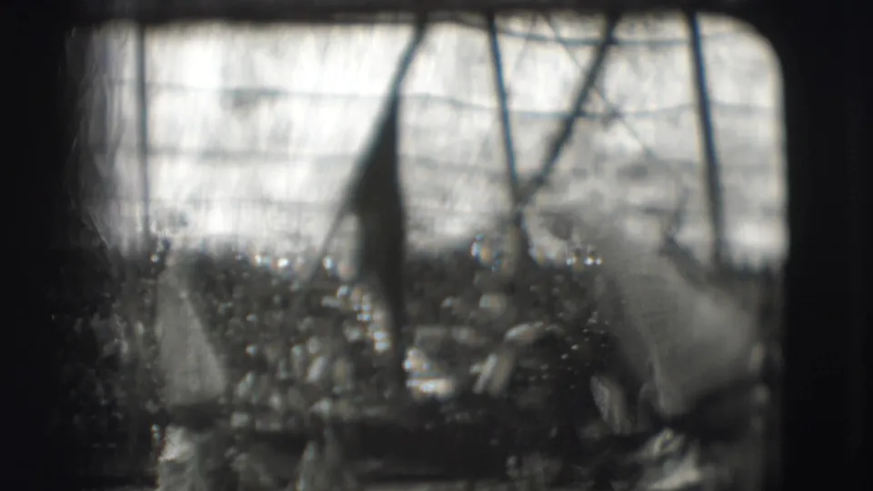 Soft 1948 Sarasota circus view through 8mm grain, showing a tall hat shape, tent poles, and a crowded audience.