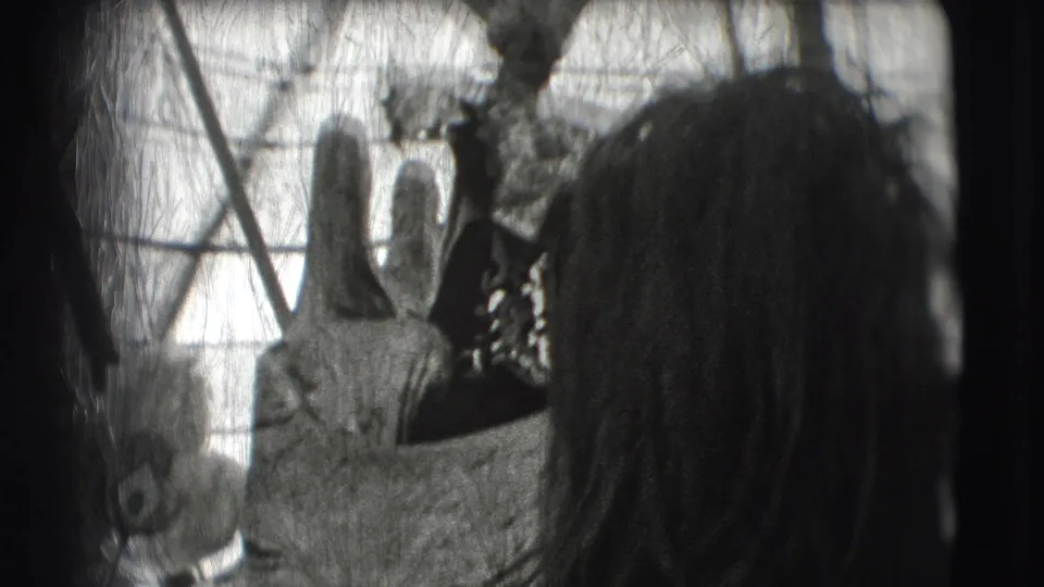 A costumed circus figure appears close to the camera while a spectator partly blocks the right side of the 8mm frame.