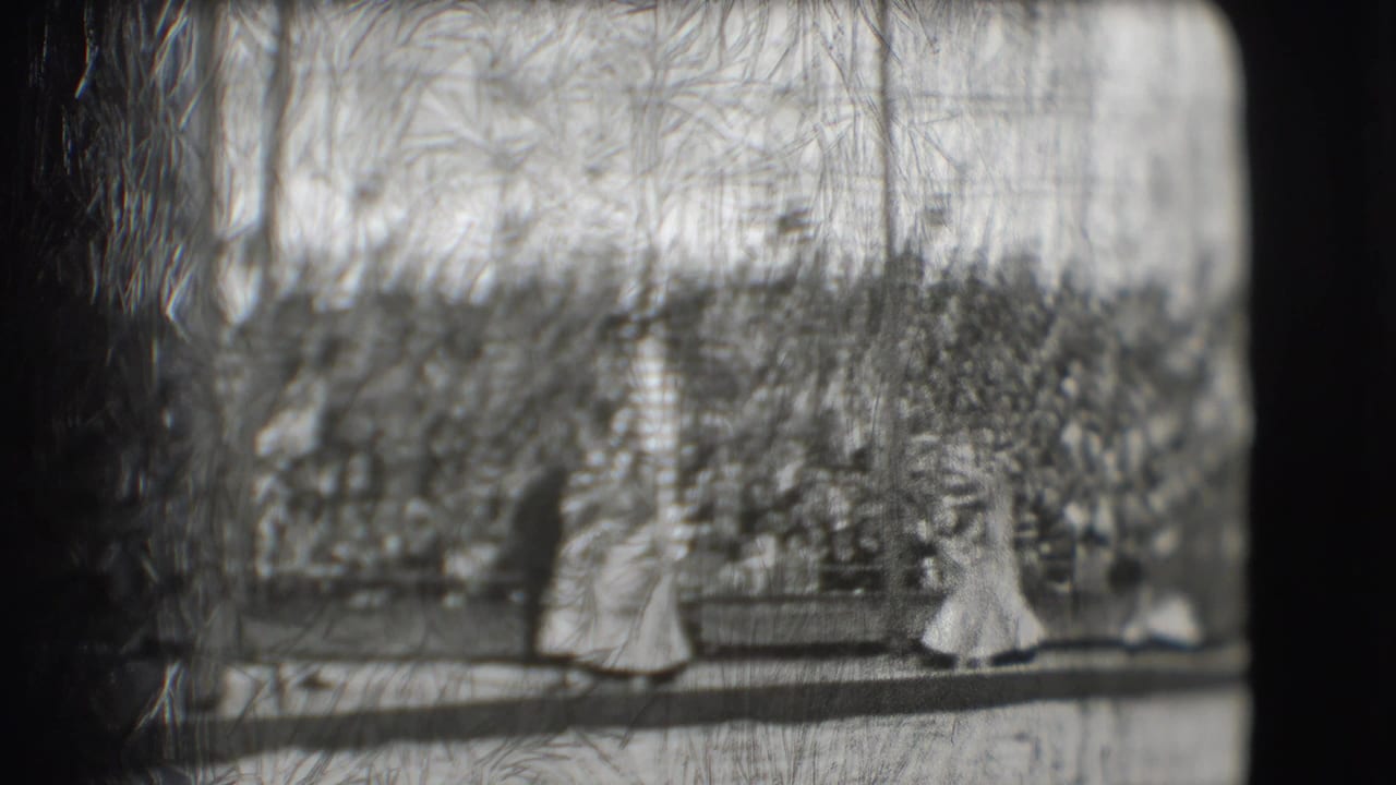 Costumed performers move along a circus ring before a packed audience.