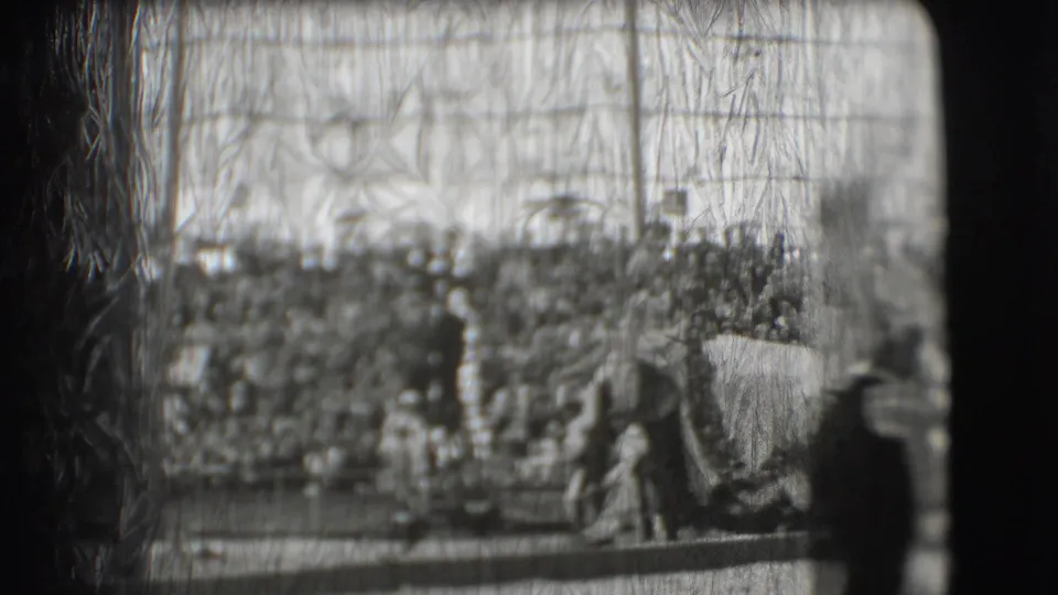 1948 Sarasota circus footage appears to show an elephant moving through the ring before a large seated crowd, seen through scratched 8mm film.