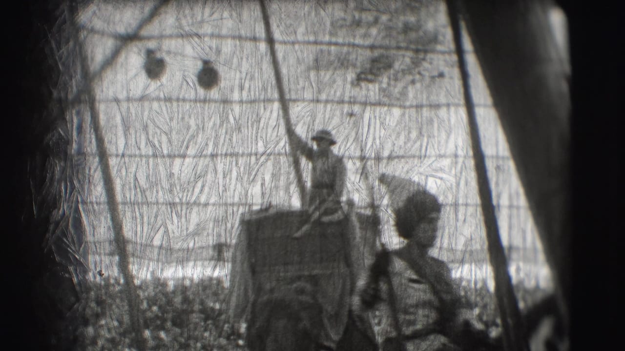Rider stands on an elephant inside a tent with another figure nearby.