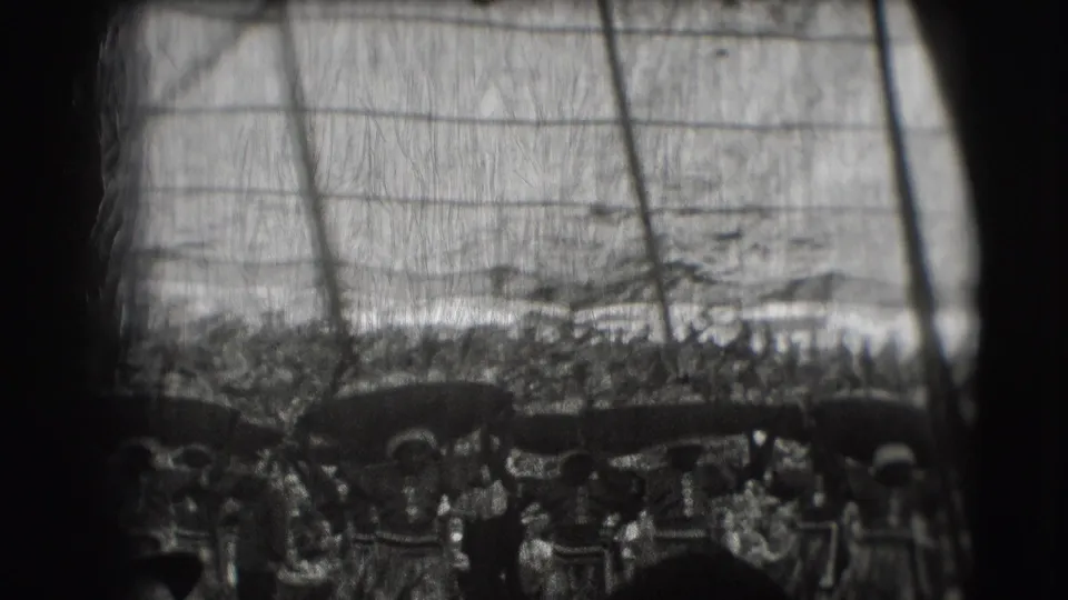 1948 Ringling Brothers Sarasota home-movie frame showing a tented crowd and women in performance dress balancing broad objects overhead.