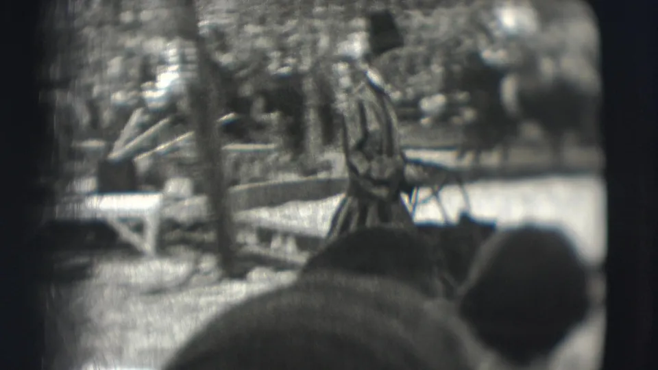 The performer and bear remain in the circus ring, with tent supports and a crowded audience visible in the 8mm frame.