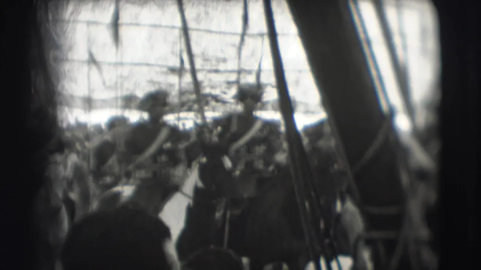 1948 Sarasota home-movie frame showing mounted uniformed riders with lances passing before a dense crowd, partly obscured by dark foreground edges.