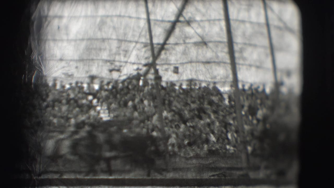 Blurred crowd and arena rail inside a circus tent.
