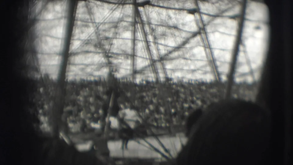 Audience-view frame from the 1948 Sarasota circus clip, showing a large crowd beyond a horse and performer in the ring.