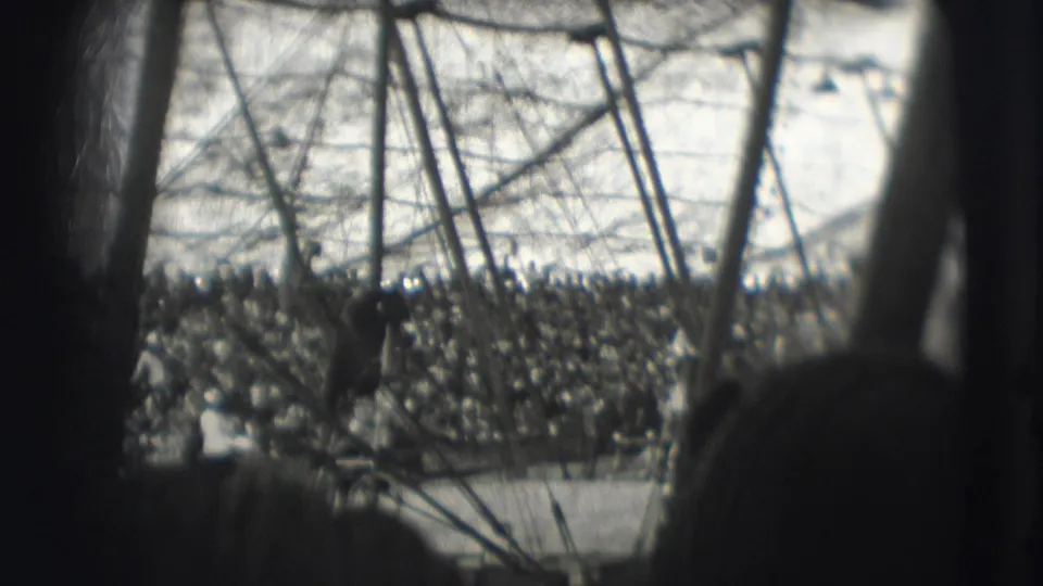 Obstructed 8mm view of the Ringling Brothers tent interior in Sarasota, with audience stands beyond the ring.