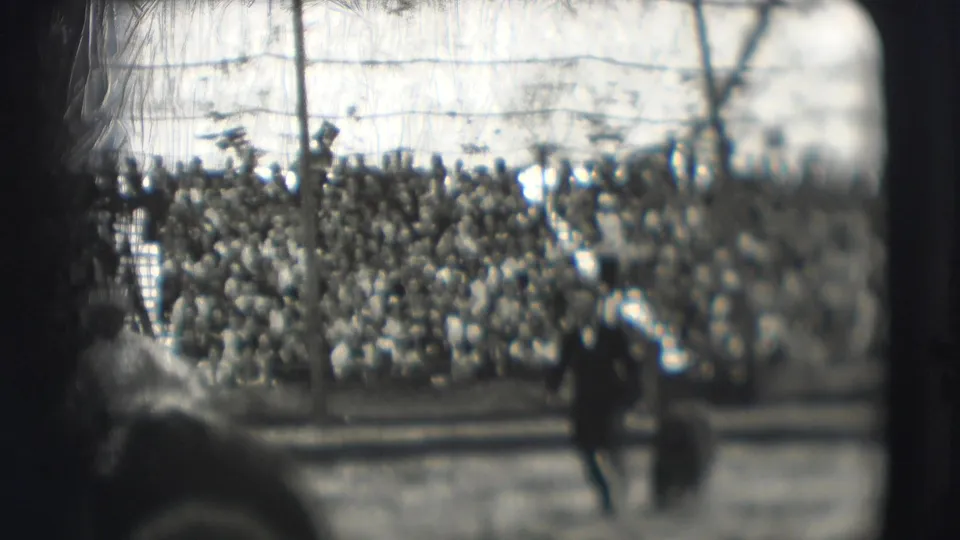 1948 Sarasota circus footage showing a dark-clad performer and bear in front of packed bleachers under a tented structure.