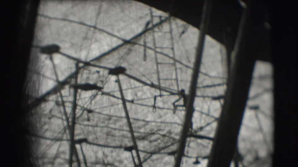 Inside the 1948 circus tent, aerial apparatus and ropes are seen from below through soft, scratched 8mm footage.