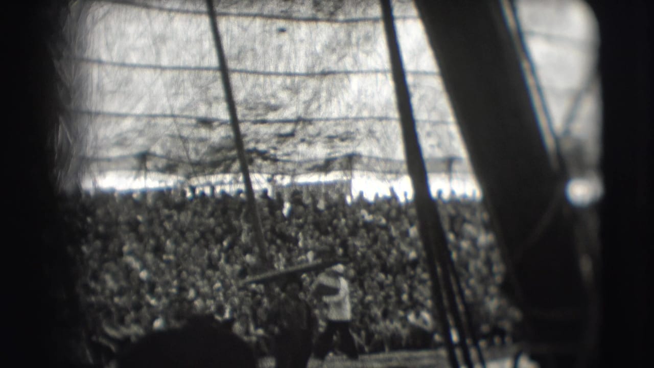 Dense Ringling Brothers Sarasota audience under tent canvas, seen in soft black-and-white 8mm with poles in foreground.