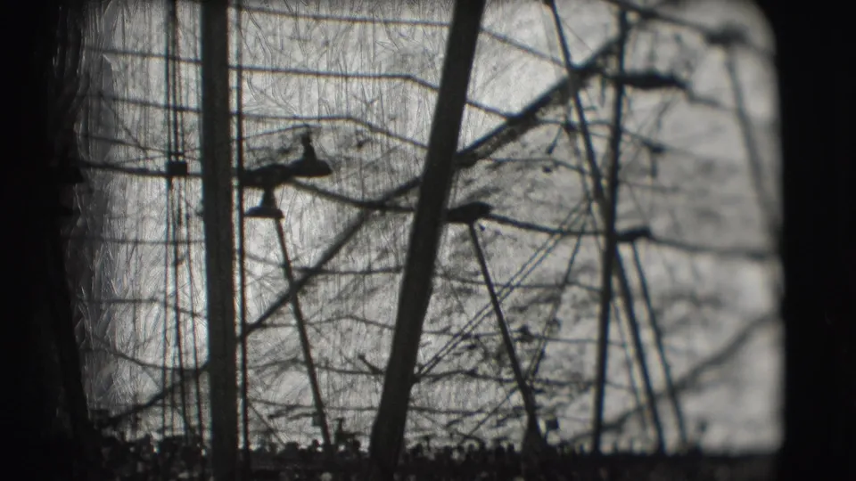 Distant black-and-white view of a circus aerial performer balanced among high wires and support poles in Sarasota, 1948.