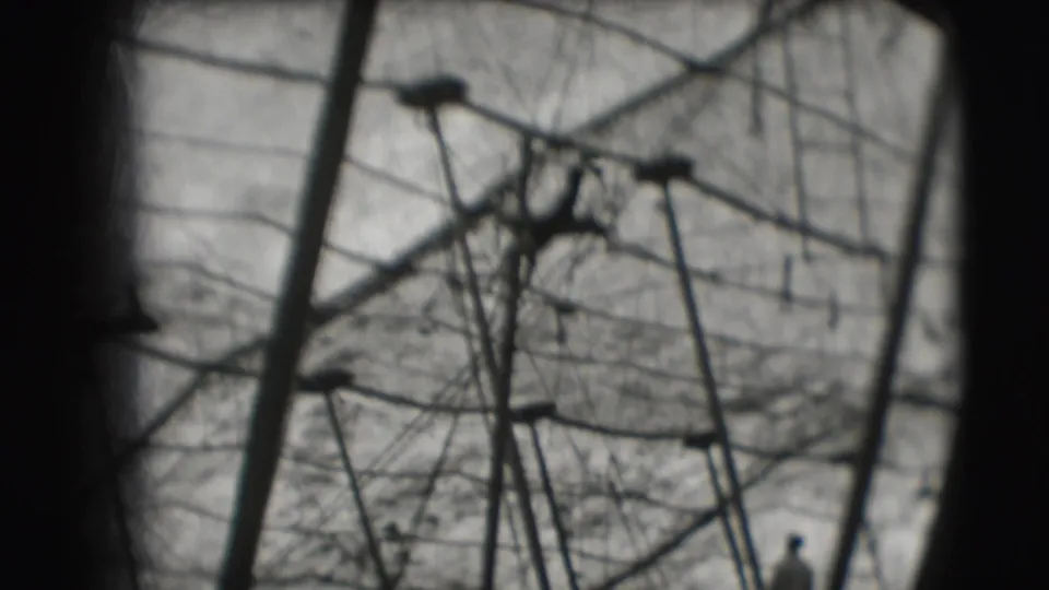 1948 Sarasota circus home-movie frame showing tent poles, wires, and canvas through a dark rounded vignette.