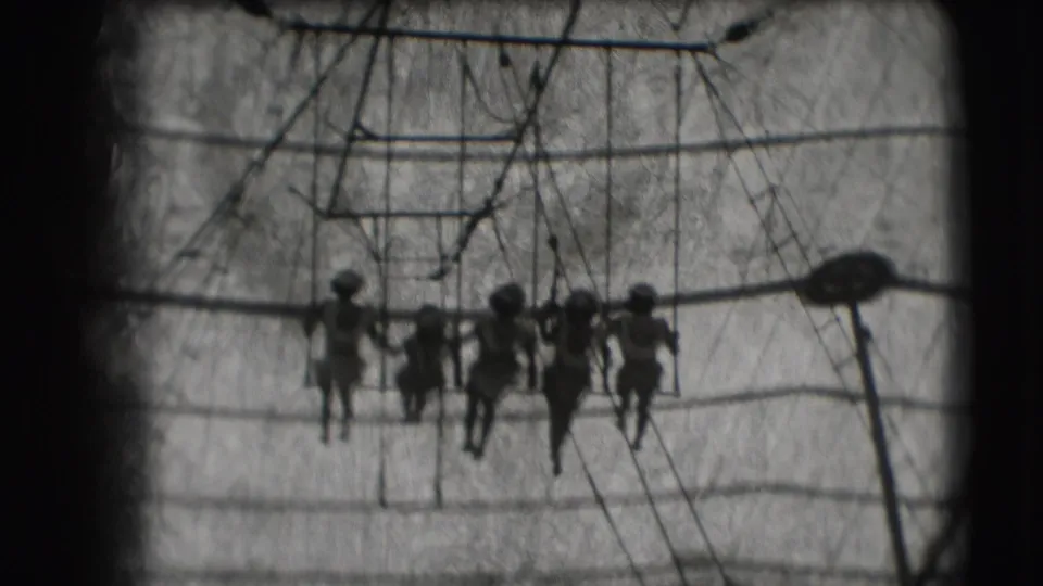 1948 Ringling Brothers Sarasota footage showing women on a trapeze swing under canvas, seen in dark silhouette.