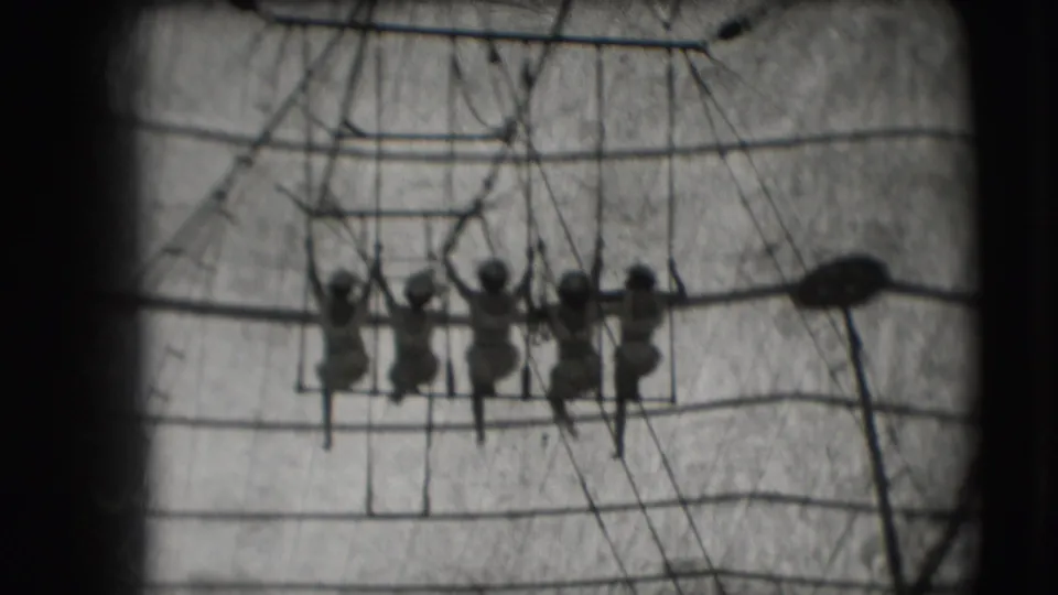 A line of women remains grouped on the trapeze swing beneath the big-top rigging in the 1948 home-movie footage.