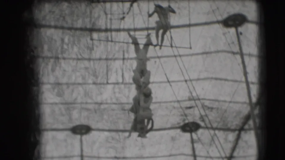 Aerial acrobats in 1948 Sarasota Ringling Brothers footage appear on the rig, with one performer higher and others suspended below.