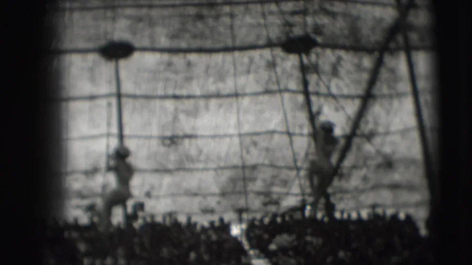 Two rope performers appear inside a circus tent in the supplied 1948 Sarasota footage, with spectators filling the lower frame.