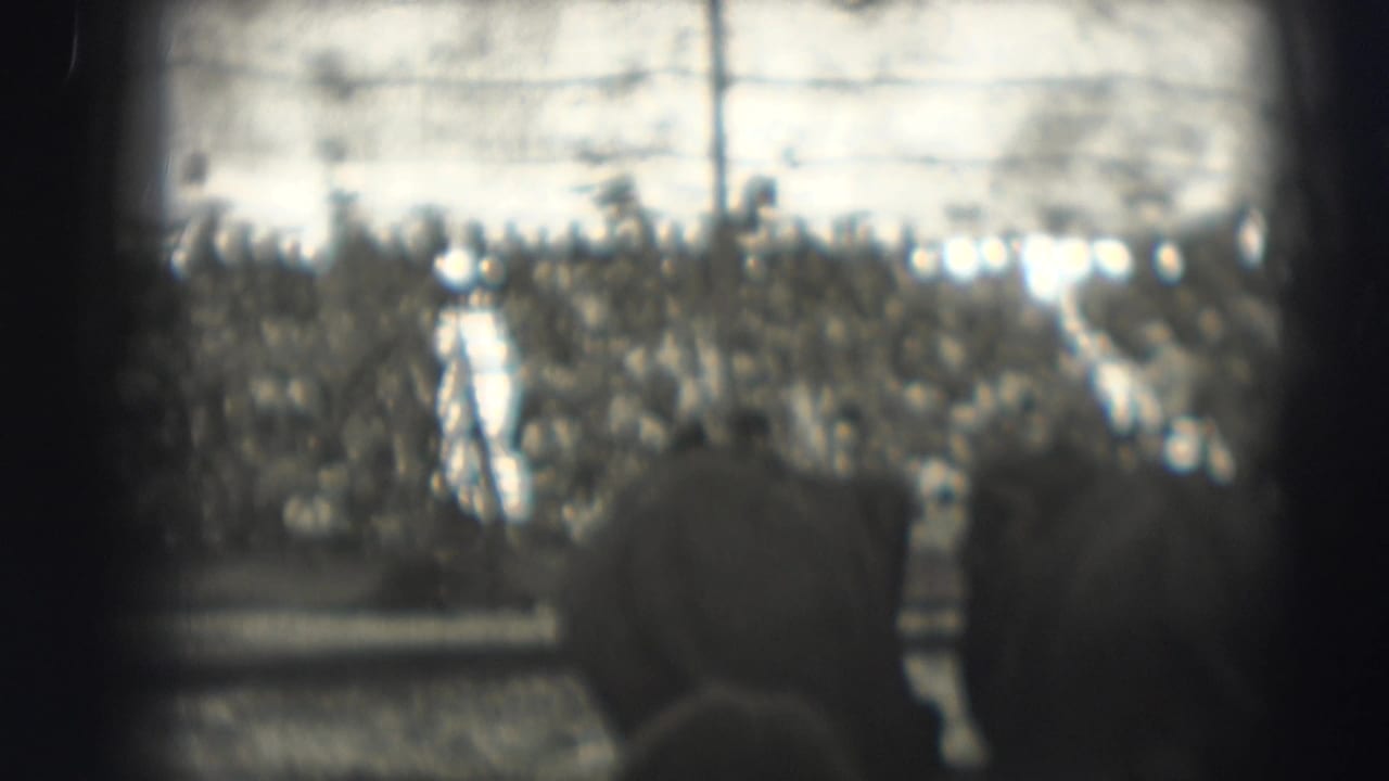 Crowded circus arena seen from behind spectators in a high-contrast black-and-white frame.