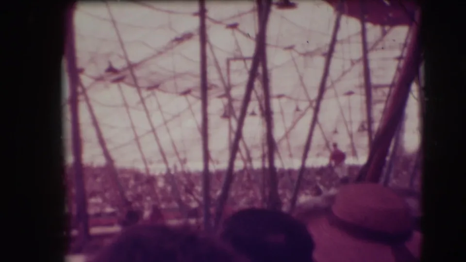 1948 Sarasota circus view from inside the big top, looking past tent poles and spectators toward a horseback performer.
