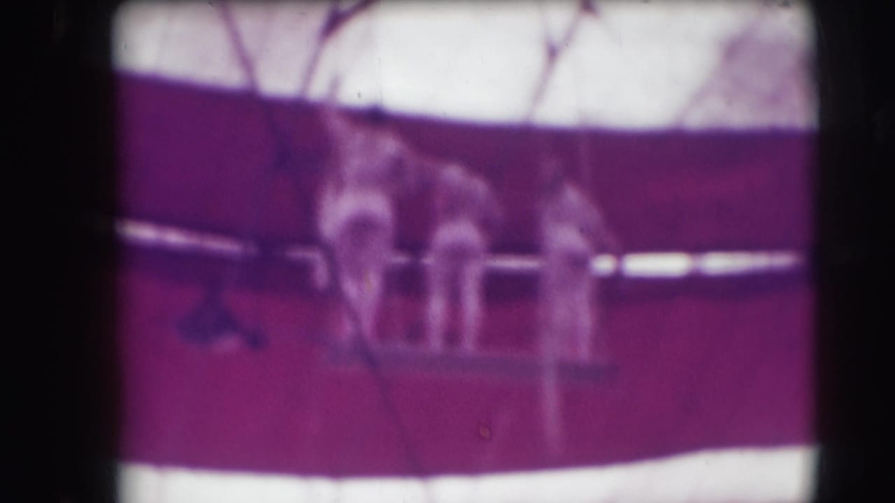 Two trapeze performers high against the red-and-white circus tent canvas.