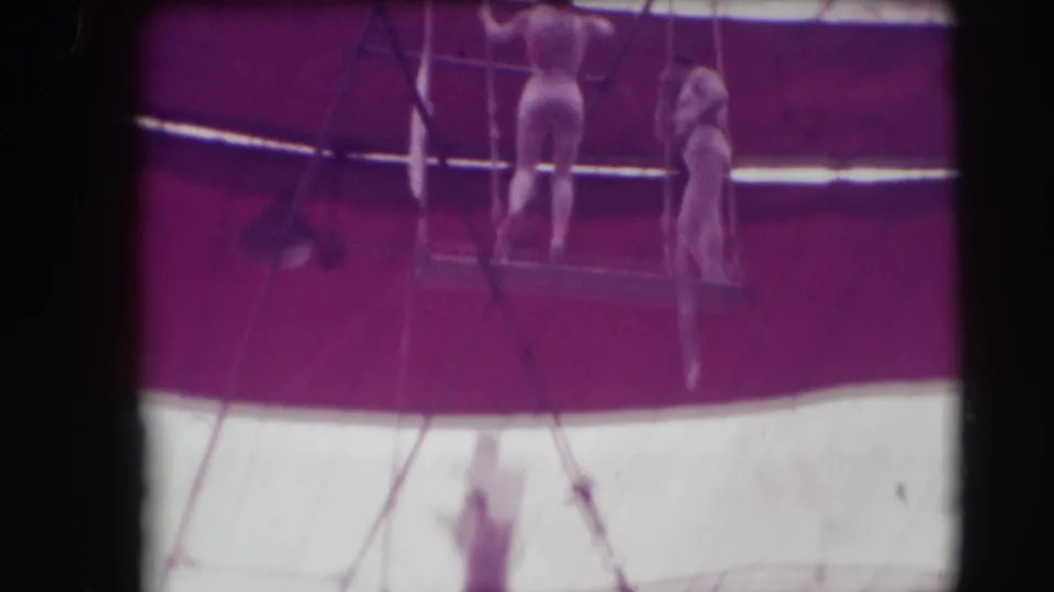 Aerial performers stand or hang near trapeze rigging inside the 1948 Sarasota Ringling Brothers circus tent.