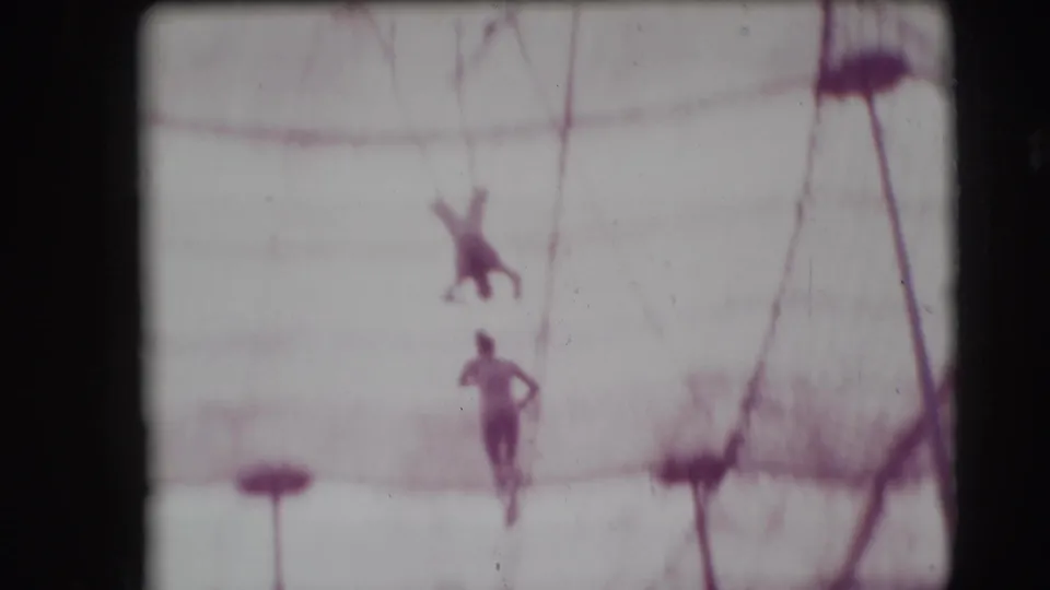 1948 Sarasota Ringling Brothers frame with aerial performers suspended near trapeze rigging above a circus safety net.