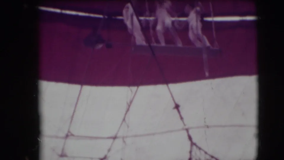 Three white-clad trapeze artists stand on a suspended platform inside the Ringling Brothers Sarasota circus tent, based on 1948 clip metadata.