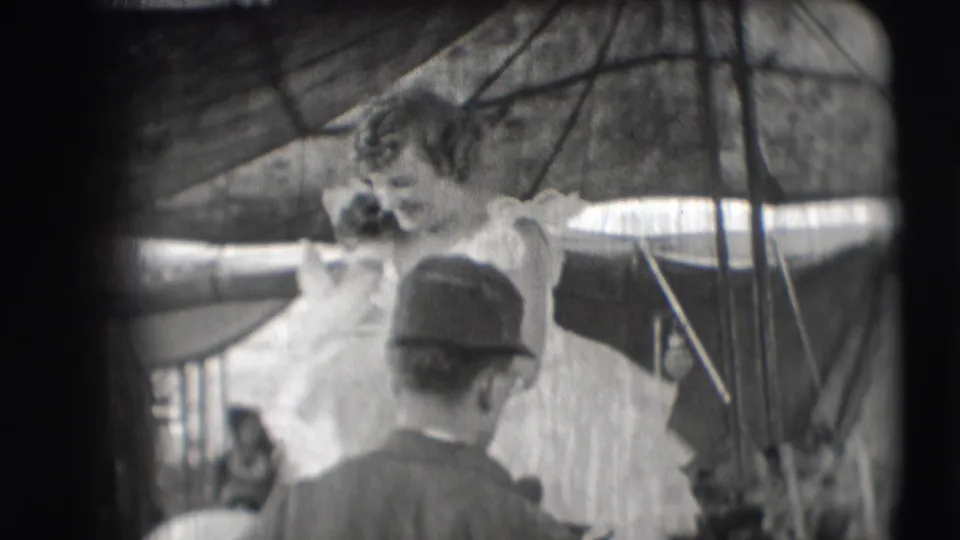 The circus performer in a flounced dress appears to lean or dismount near the horse while a man watches under the tent.
