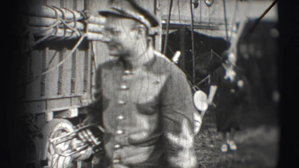 A uniformed circus musician remains near the wagon and rigging, with other uniformed figures partly visible in the background.
