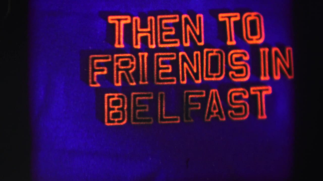 Neon-style sign reading THEN TO FRIENDS IN BELFAST against a blue-purple background.