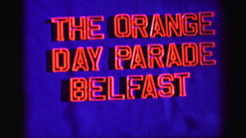 The Belfast parade title card continues, with saturated blue and red colors typical of the scanned 8mm material.