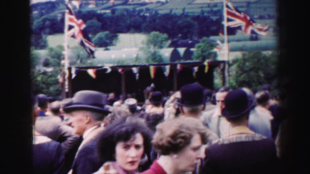 Crowd at a rural outdoor stall with Union Jack flags and bunting.