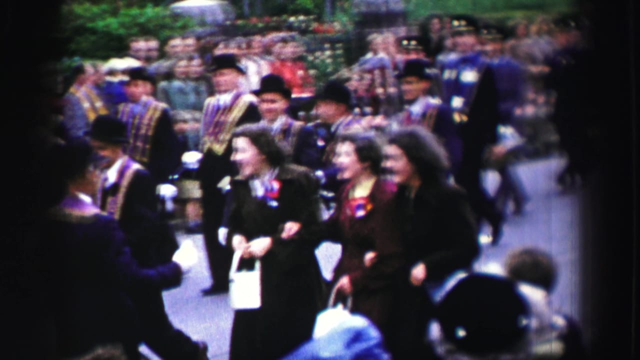 United Kingdom 1952 parade scene with sash-wearing marchers, women in dark coats, and spectators lining the route.