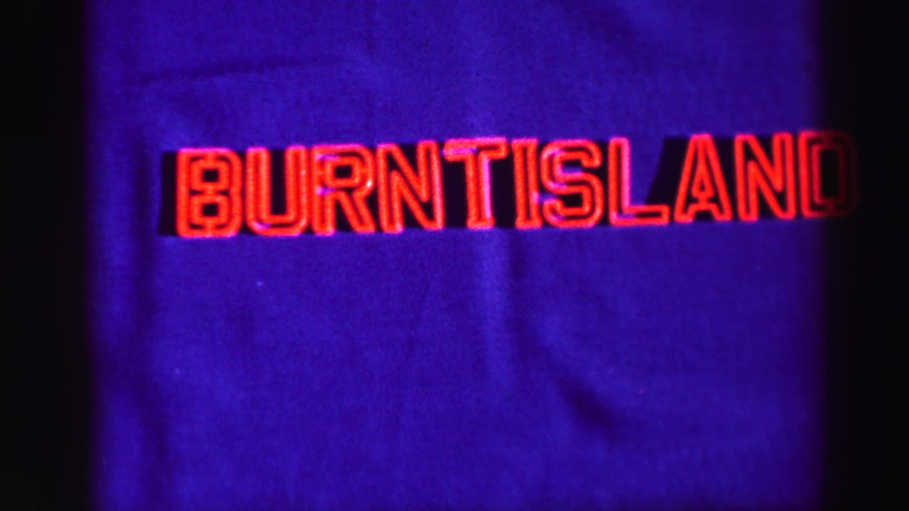 1952 8mm frame with red Burntisland title lettering on a purple-blue background, framed by dark film edges.