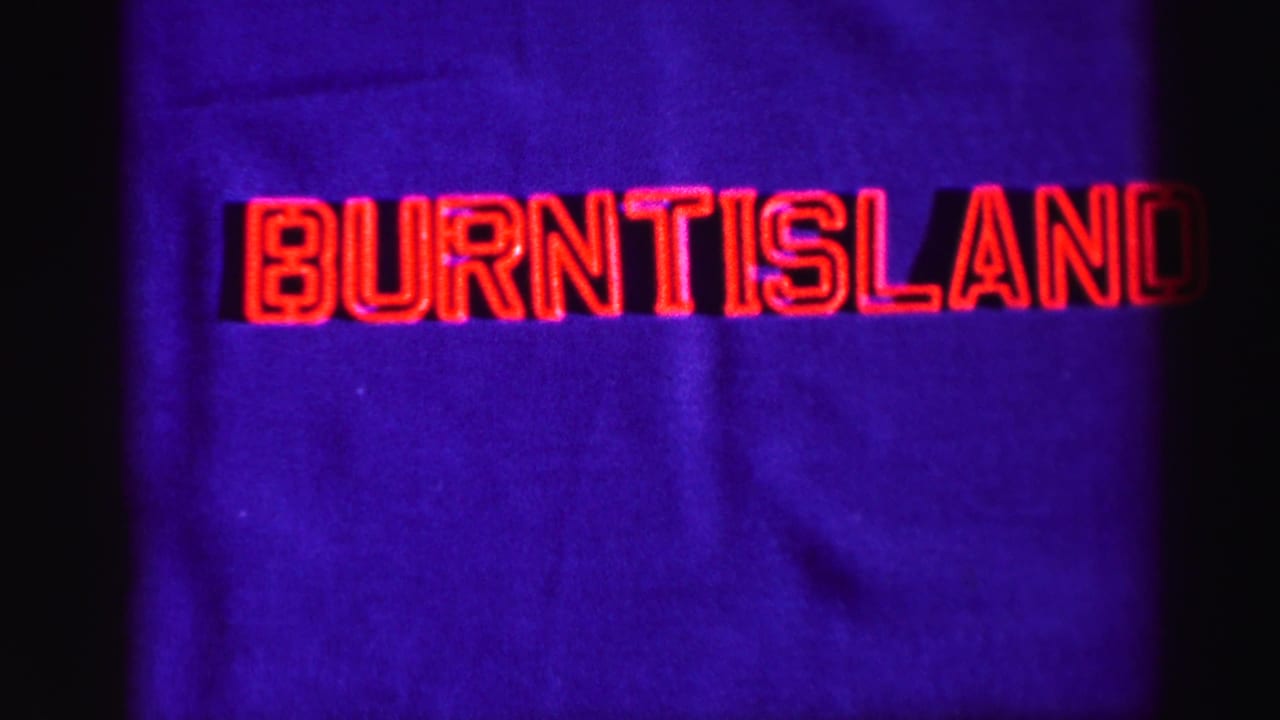 1952 8mm Burntisland title frame with red outlined lettering, purple-blue field, and dark vertical film border.