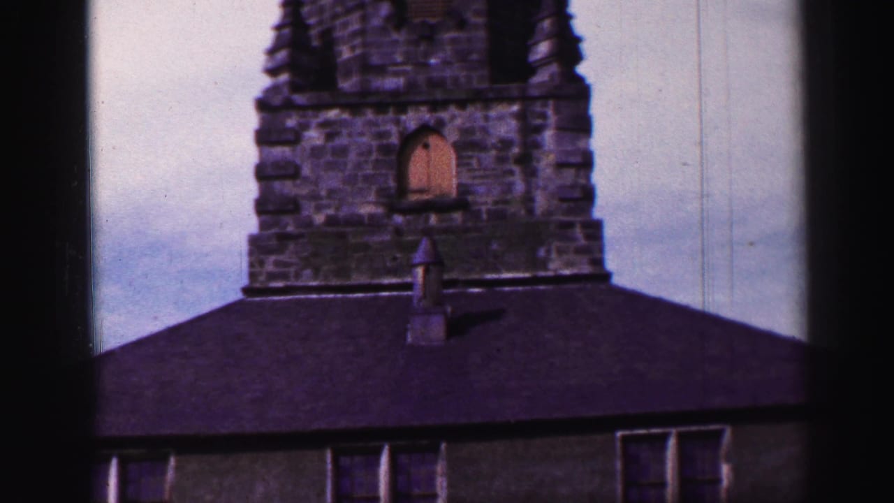 Weathered tower and roofline with part of the building wall below.